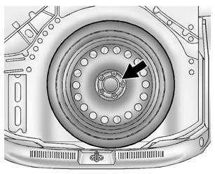 3. Turn the retainer counterclockwise and remove it from the compact spare.