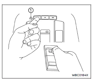 Nissan Armada HomeLink programming position with handheld transmitter near console